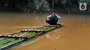 Seorang anak menyeberangi Sungai Cikaniki dengan rakit di Rumpin, Bogor, Jawa Barat, Rabu (15/1/2020). Akibat banjir bandang merobohkan jembatan yang menghubungkan Desa Tonjong Rumpin dan Desa Kantalarang Leuwiliang, warga terpaksa memanfaatkan perahu rakit untuk melintas. (merdeka.com/Arie Basuki)