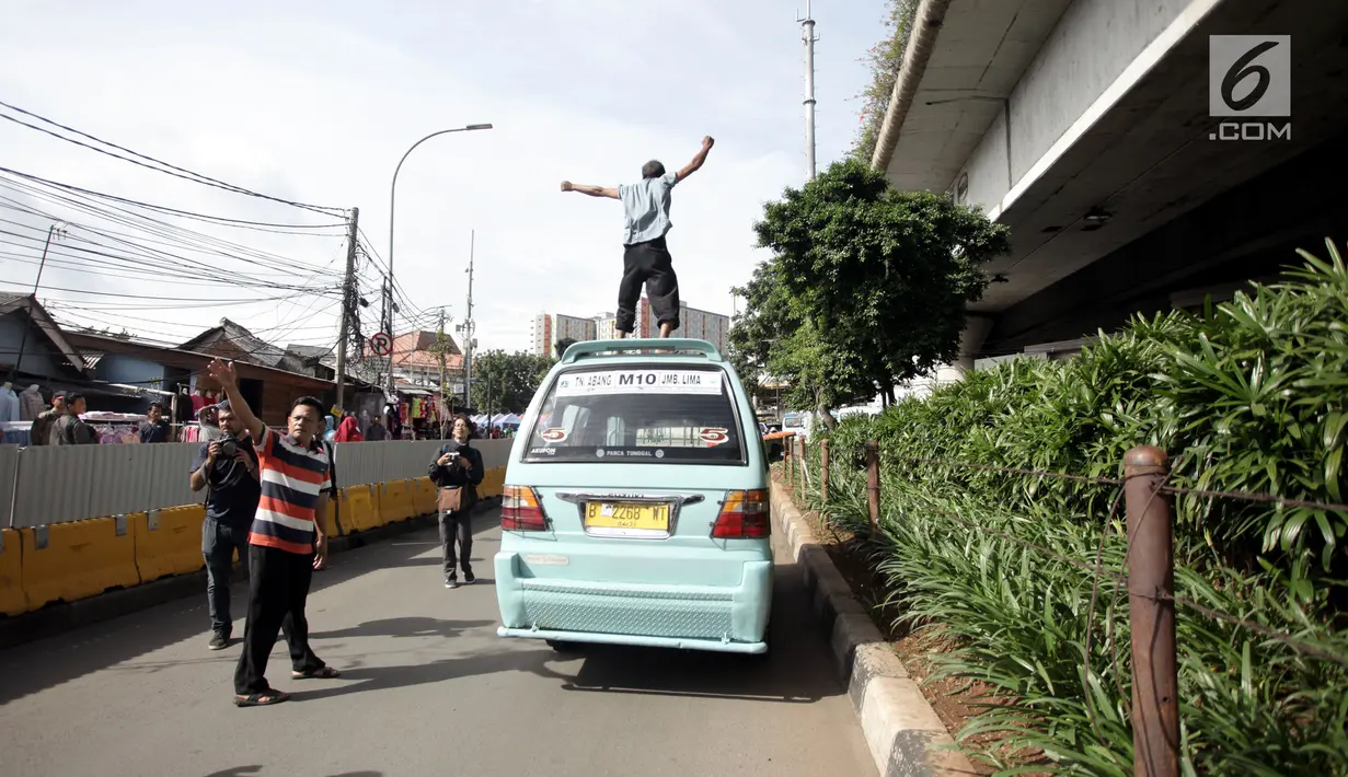 Seorang sopir angkot berorasi dengan menaiki kendaraannya saat unjuk rasa di Jalan Jatibaru, Tanah Abang, Jakarta, Senin (29/1). Para pengunjuk rasa adalah para sopir angkot trayek M08, M10, YP03, M09, M11, dan M9A. (Liputan6.com/Arya Manggala)