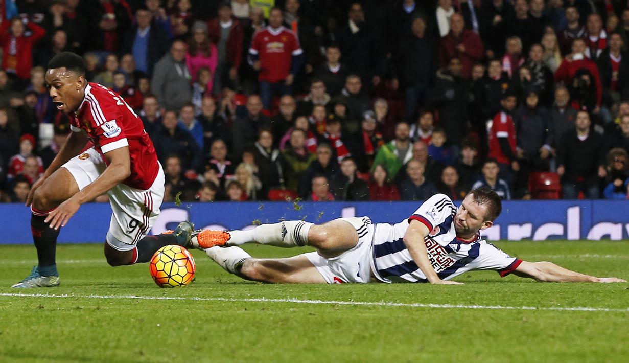 Penyerang MU, Anthony Martial dijatuhkan pemain WBA, Gareth McAuley pada laga Liga Premier Inggris di Stadion Old Trafford, Inggris, Sabtu (7/11/2015). (Reuters/Andrew Yates)