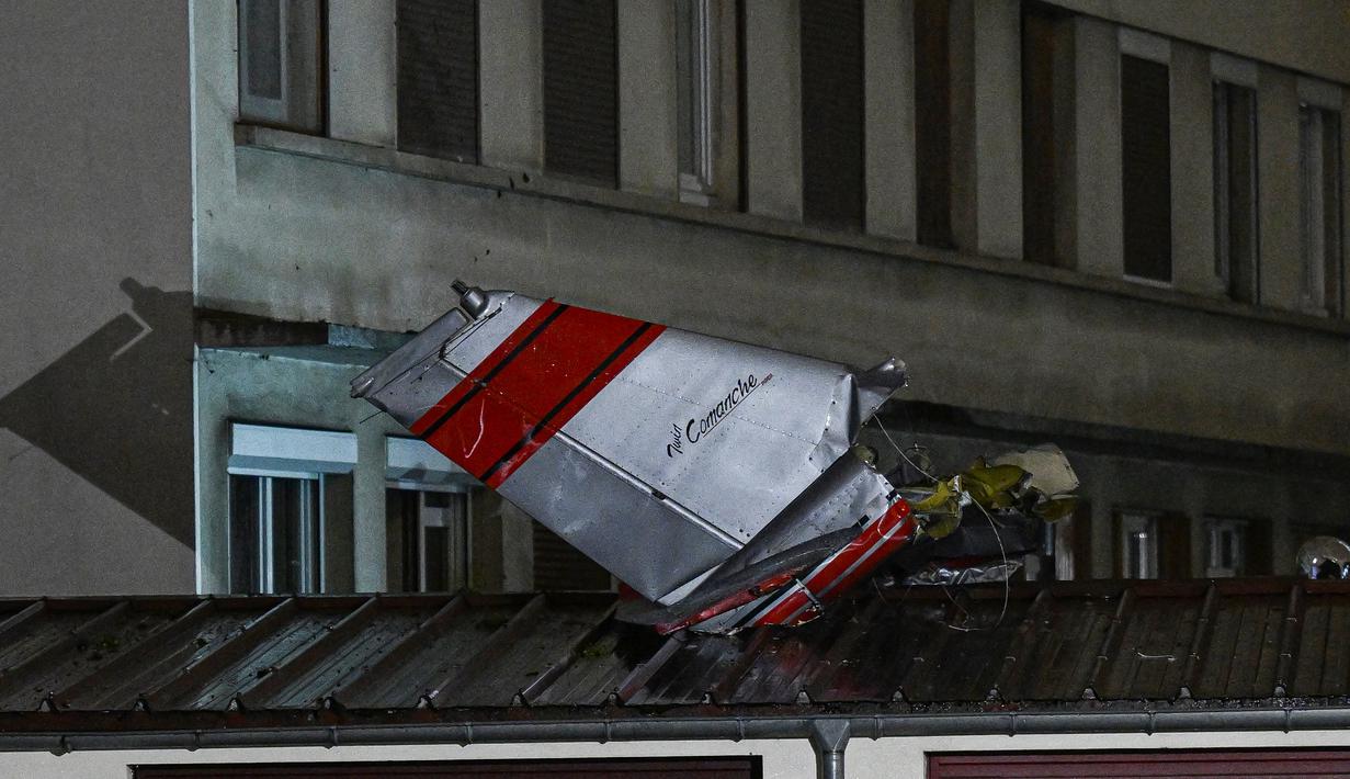 Pesawat itu akhirnya berhenti di taman di bagian belakang gedung apartemen, dengan bagian-bagian pesawat berserakan di atap garasi di dekatnya, dan badan pesawat hancur akibat benturan. (Miguel MEDINA / AFP)