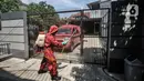 Petugas damkar Kecamatan Cipayung menyemprotkan disinfektan saat sterilisasi wilayah Zona Merah di RT 003/003, Kelurahan Cilangkap, Jakarta, Selasa (25/5/2021). Kawasan ini setelah ditetapkan sebagai Zona Merah usai lebih dari 100 warga dikabarkan positif Covid-19. (merdeka.com/Iqbal S Nugroho)