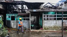 Petugas pemadam kebakaran melintas di depan salah satu rumah warga yang terbakar di Jalan Masjid Alhuda atau depan Stasiun Kebayoran Lama RT 05/01, Jakarta Selatan, Selasa (24/5/2022). Petugas pun mengerahkan 27 unit mobil pemadam kebakaran dari Sudin Damkar Jakarta Selatan ke lokasi kejadian. (Liputan6.com/Johan Tallo)