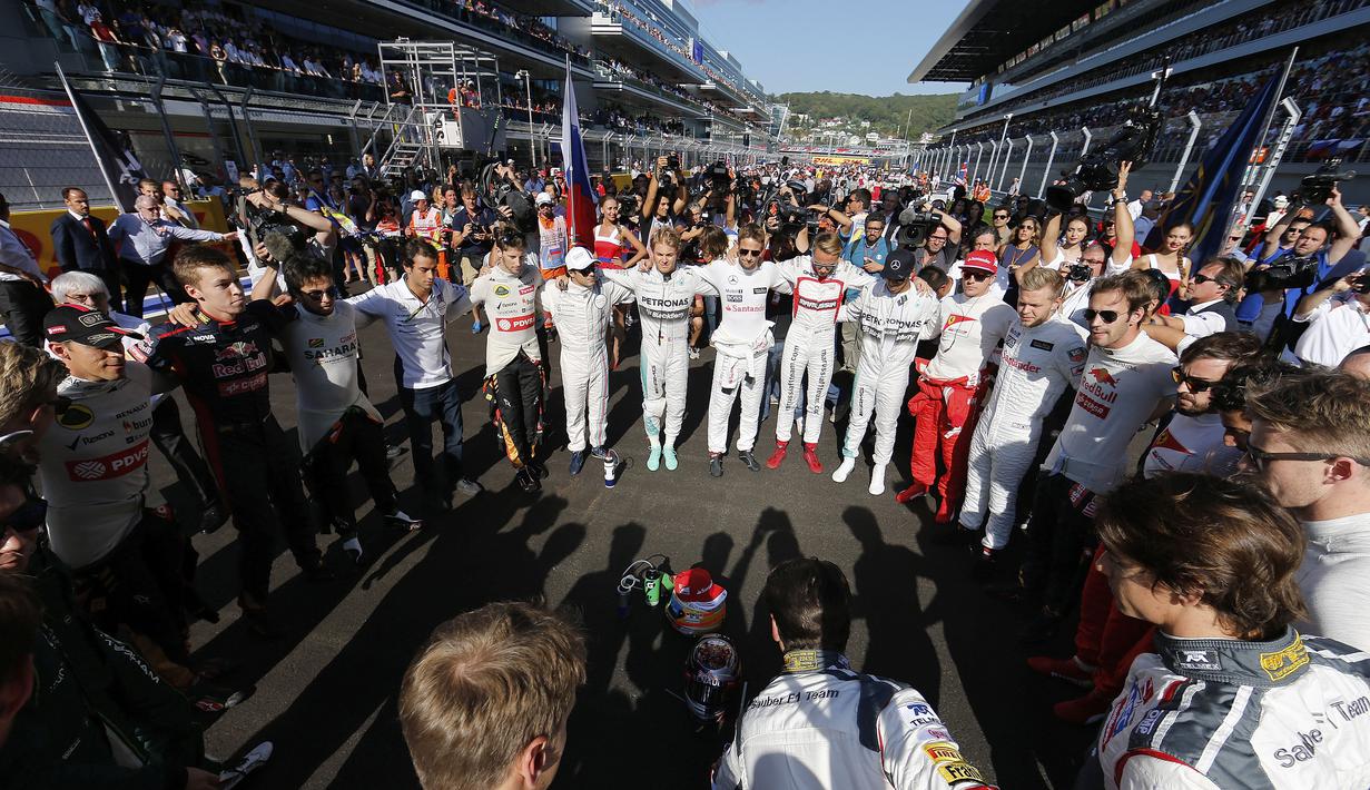 Pebalap F1 berdoa bersama untuk Jules Bianchi sebelum memulai balapan F1 GP Rusia di Sirkuit Sochi Autodrom, Rusia. (12/10/2014). (Valdrin Xhemaj/Pool Photo via AP, File)