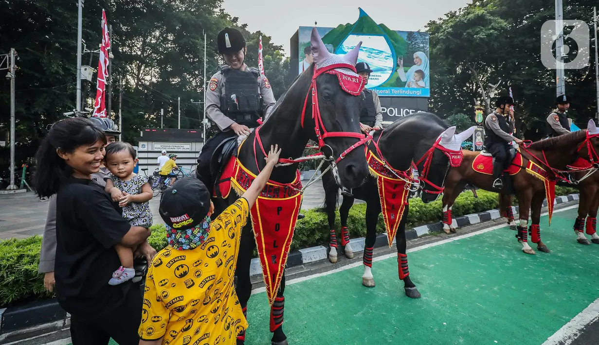 Anak-anak menyentuh kuda yang ditunggangi polisi saat mengamankan CFD. (Liputan6.com/Faizal Fanani)