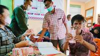 Seorang petani Kopsa-M memperlihatkan dana talangan yang diperoleh untuk bekal Lebaran Idul Fitri. (Liputan6.com/M Syukur)