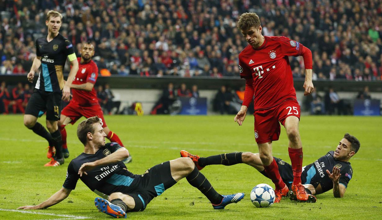Pemain Arsenal Nacho Monreal dan Gabriel Paulista  berebut bola dengan pemain Bayern Munich Thomas Muller pada lanjutan Liga Champion di Allianz Arena, Munich, Jerman, Kamis (5/11/15) dini hari. Bayern menang 5-1. (Action Images via Reuters / John Sibley)