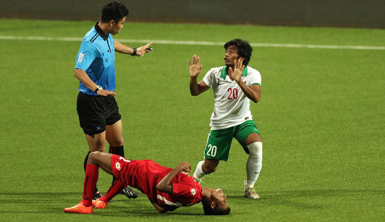 Pemain Timnas Indonesia U-23, Ilham Udin Armayn (kanan), berbicara dengan wasit Kim Heegon setelah melakukan pelanggaran terhadap pemain Myanmar U-23. (Bola.com/Arief Bagus)