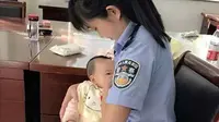 Seorang petugas pengadilan menyusui anak perempuan yang tengah diadili. (China Daily/Asia News Network)