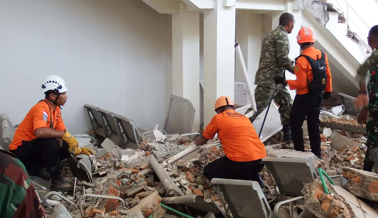 Tim penyelamat mencari korban di reruntuhan setelah gempa berkekuatan magnitudo 7,7 mengguncang Pulau Flores di  Pelabuhan Laurensius Say di Maumere, Sikka, Nusa Tenggara Timur, Sabtu, 15 Agustus 2026. (AFP/ Arnold Welianto)