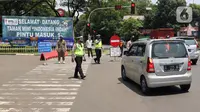 Polisi mengatur lalu lintas saat pengendalian mobilitas ganjil genap untuk pengunjung TMII di Jalan Pintu 1 TMII, Jakarta, Sabtu (18/9/2021). Pembatasan mobilitas pada TMII dan Taman Impian Jaya Ancol dilakukan pada hari Jumat-Minggu mulai pukul 12.00-18.00 WIB. (Liputan6.com/Herman Zakharia)