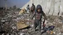 Seorang anak Afghanistan yang kehilangan tempat tinggalnya mencari barang-barang plastik dan lainnya yang dapat digunakan sebagai pengganti kayu bakar, di tempat pembuangan sampah di Kabul, Afghanistan (15/12/2019). (AP Photo/Altaf Qadri)