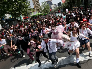 Ratusan orang berkostum menyerupai zombie berpartisipasi dalam perayaan satu dekade Zombie Walk di Santiago, Chile, 13 Oktober 2018. Zombie Walk merupakan acara tahunan yang terinspirasi dari acara televisi AS 'The Walking Dead'. (AP/Esteban Felix)