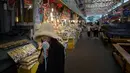 Seorang wanita mendinginkan diri menggunakan kipas portabel saat melewati pasar di Seoul, Korea Selatan, Rabu (1/8). Menurut pejabat pemerintah, lebih dari 28 orang meninggal dunia karena gelombang panas di Korea Selatan. (Ed JONES/AFP)
