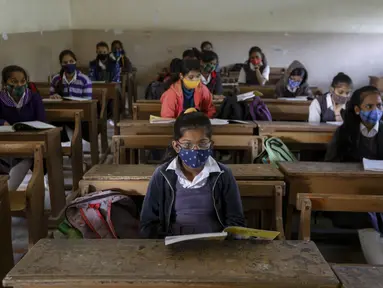 Siswa yang mengenakan masker menghadiri kelas saat sekolah dibuka kembali setelah ditutup selama berbulan-bulan karena pandemi COVID-19 di Ahmedabad, India, Senin (11/1/2021). Negara bagian Gujarat telah membuka kembali sekolah hanya untuk kelas 10 dan 12. (AP Photo/Ajit Solanki)