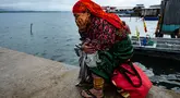 Seorang perempuan Penduduk Asli Guna menunggu di dermaga untuk pemindahannya dari pulau Carti Sugtupu ke daratan, di Guna Yala Comarca, di pantai Karibia di Panama, pada 03 Juni 2024. (MARTIN BERNETTI / AFP)