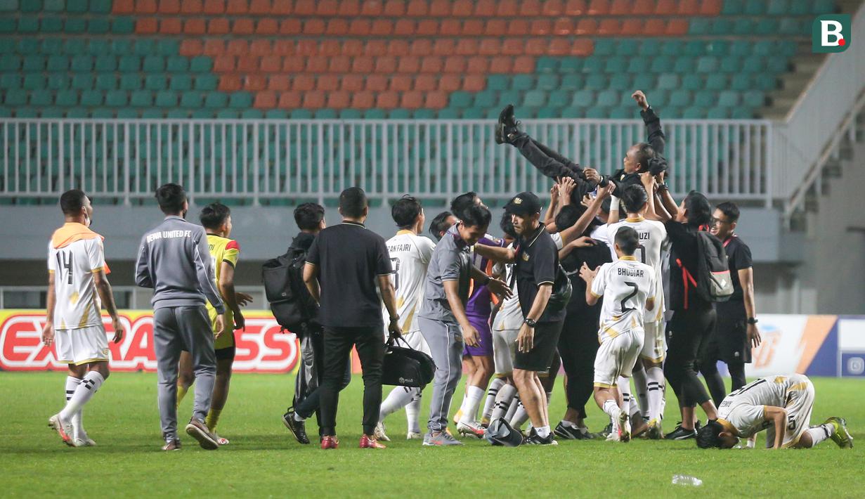 Para pemain dan tim ofisial Martapura Dewa United merayakan keberhasilan promosi ke BRI Liga 1 dengan mengangkat pelatih Kas Hartadi usai menang 1-0 atas PSIM Yogyakarta dalam laga perebutan tempat ketiga Liga 2 2021 di Stadion Pakansari, Bogor, Kamis (30/12/2021). (Bola.com/Bagaskara Lazuardi)