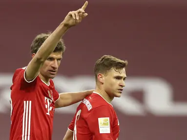 Pemain Bayern Munchen Joshua Kimmich (kanan) merayakan bersama Thomas Mueller usai mencetak gol ke gawang Bayer Leverkusen pada pertandingan Bundesliga di Stadion Allianz Arena, Munchen, Jerman, Selasa (20/4/2021). Bayern Munchen menang 2-0. (AP Photo/Matthias Schrader, Pool)