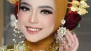 Penampilan Putri Isnari di momen Hantaran Uang Panai pun tampak mencuri perhatian netizen. Dirinya tampil dengan busana tradisional bernuansa cokelat dan emas dengan makeup flawless. (Liputan6.com/IG/@mrd_mua)