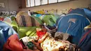 Seorang pria terbangun di gimnasium yang ditempati migran di lycee Jeanne-Bernard di Saint-Herblain, Nantes, Prancis (28/3). Sebuah keputusan pengadilan 28 Maret 2019, menyusul  permintaan  keuskupan, pemilik situs, untuk mengusir para migran yang menempati gymnasium.  (AFP Photo/Loic Venance)