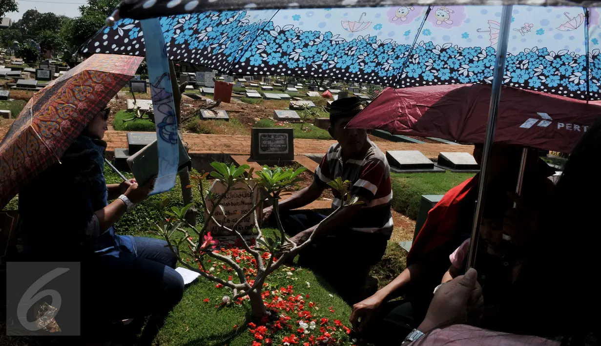 Sejumlah umat muslim berdoa di makam keluarga saat ziarah kubur di TPU Karet Bivak, Jakarta, Sabtu (18/7/2015). Ziarah kubur dilakukan umat muslim untuk mendoakan mendiang keluarga dan kerabat mereka yang telah meninggal. (Liputan6.com/JohanTallo)