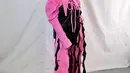Jinan pernah manggung di F1 Night Race dengan busana hitam pink yang nyentrik. Outfit yang terdiri dari jumpsuit dengan detail kerah kerah dan lengan pleated serta rumbai hitam sebagai aksen. [@jinanlaetitia]