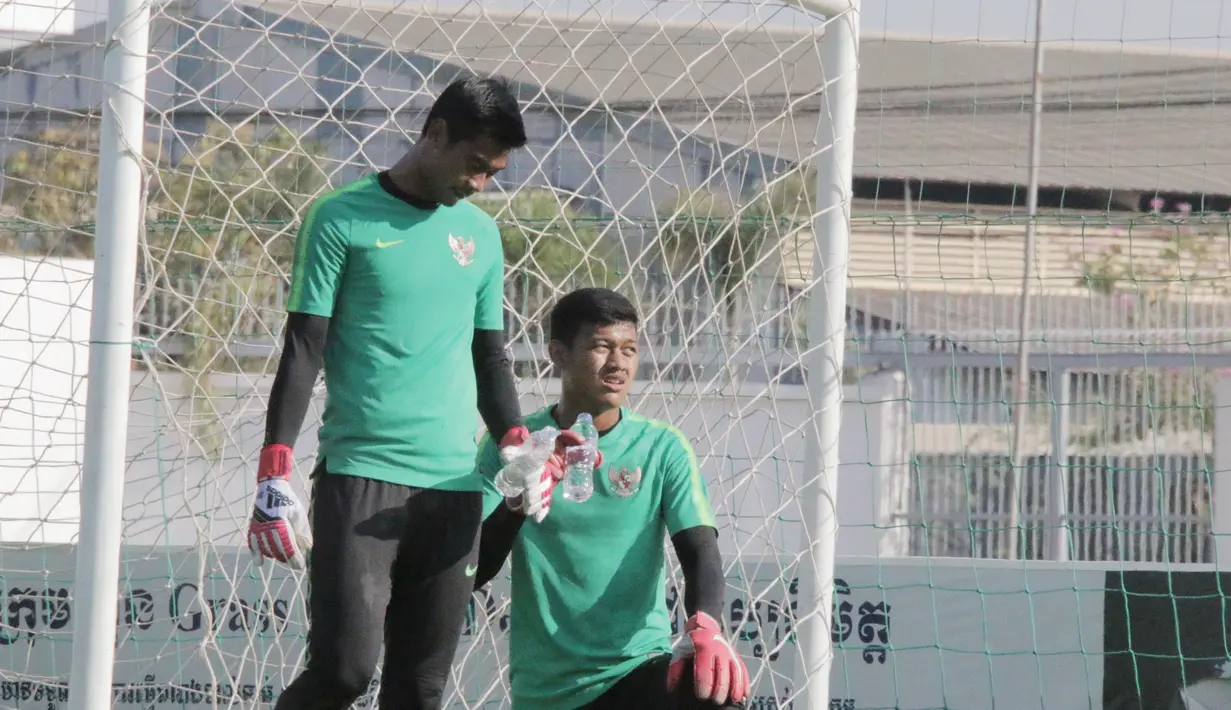 Kiper Timnas Indonesia U-22, Satria Tama dan Muhammad Riyandi, melepas dahaga saat latihan di Lapangan AUPP, Phnom Penh, Selasa (19/2). Latihan ini persiapan jelang laga Piala AFF U-22 melawan Malaysia. (Bola.com/Zulfirdaus Harahap)