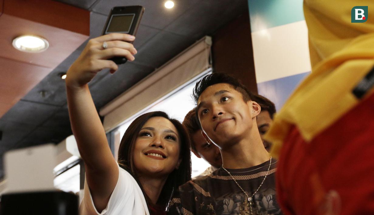 Peraih emas bulutangkis, Jonatan Christie, foto bersama fans saat pemberian apresiasi di Sarinah, Jakarta, Rabu (5/9/2018). Peraih medali dari cabor bulutangkis dan wushu mendapat penghargaan berupa logam mulia. (Bola.com/M Iqbal Ichsan)