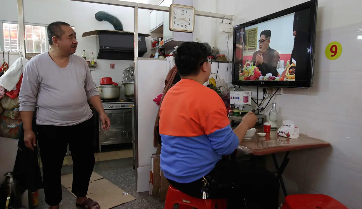 Warga menonton berita CCTV pagi di TV kunjungan pemimpin Korea Utara Kim Jong Un ke China, di sebuah restoran di daerah Jiexi di provinsi Guangdong China selatan, (28/3). Ini merupakan lawatan pertama Kim sejak menjabat pada 2011. (AP Photo/Andy Wong)