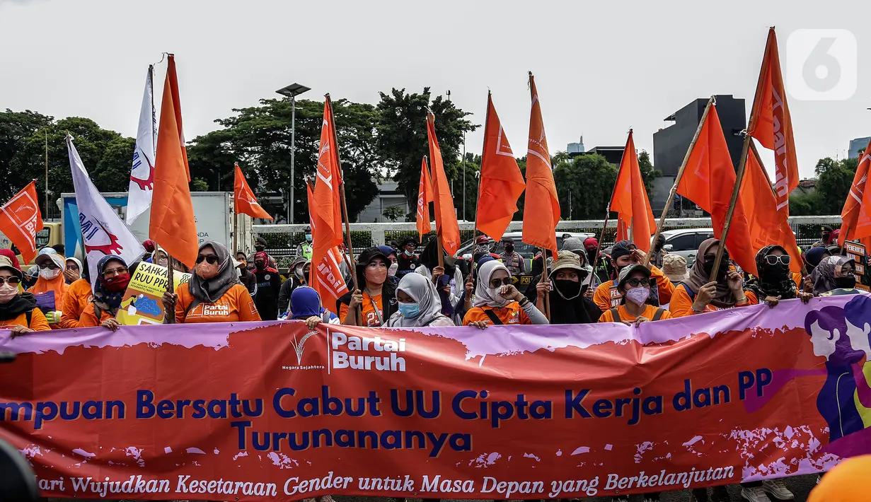 Sejumlah buruh perempuan memegang poster saat menggelar aksi di depan gedung DPR RI, Jakarta, Selasa (8/3/2022). Buruh perempuan yang tergabung dari beberapa serikat buruh menggelar aksi memperingati Hari Perempuan Internasional atau International Women's Day (IWD) 2022. (Liputan6.com/Johan Tallo)