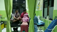 Polisi tak bisa memarkirkan mobil di halaman rumah ibu yang hendak melahirkan itu. Polisi dan warga akhirnya harus menggotongnya hingga ke dalam mobil. (dok. Polres Lebak/Yandhi Deslatama)