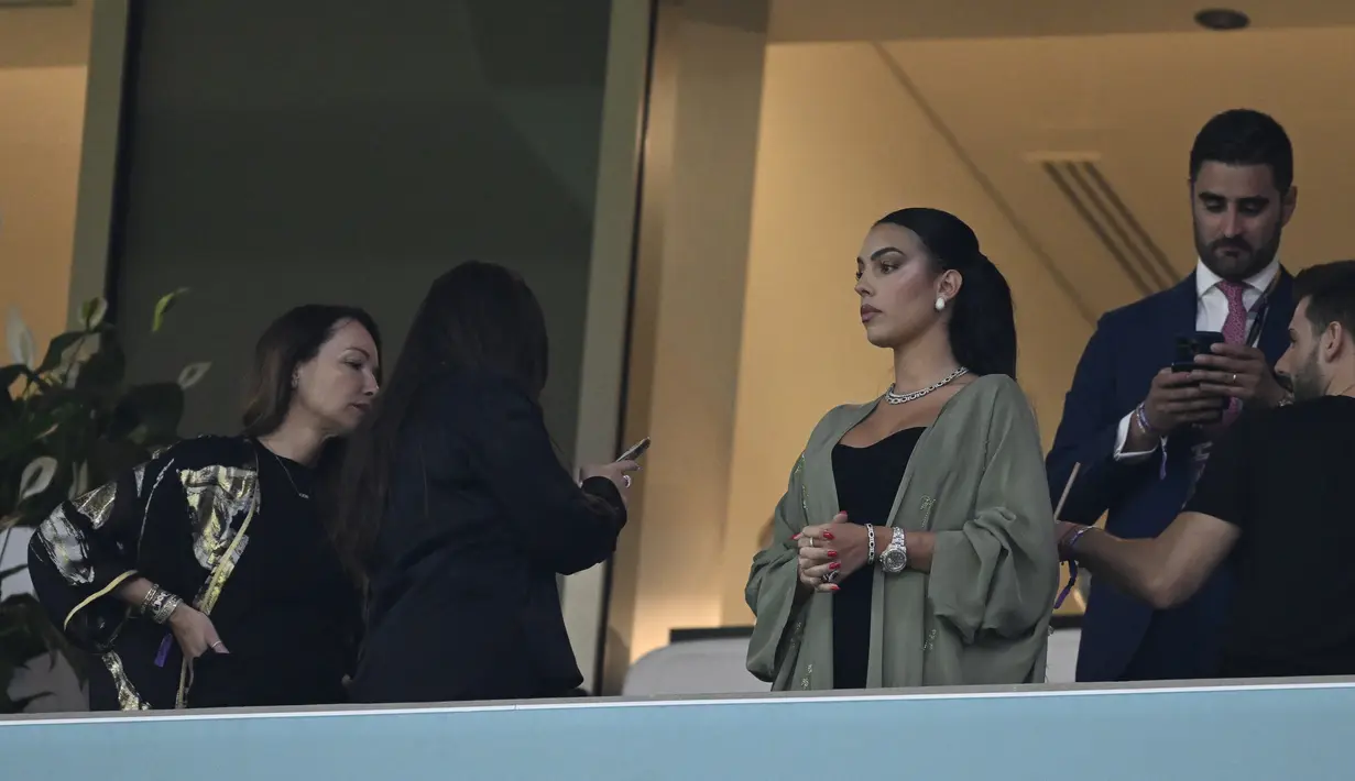 Georgina Rodriguez  menghadiri pertandingan babak 16 besar Piala Dunia Qatar 2022 antara Portugal dan Swiss di Stadion Lusail di Lusail, utara Doha (6/12/2022). Georgina Rodriguez juga terlihat cantik mengenakan mantel cokelat dan mengikat rambutnya. (AFP/Patricia De Melo Moreira)