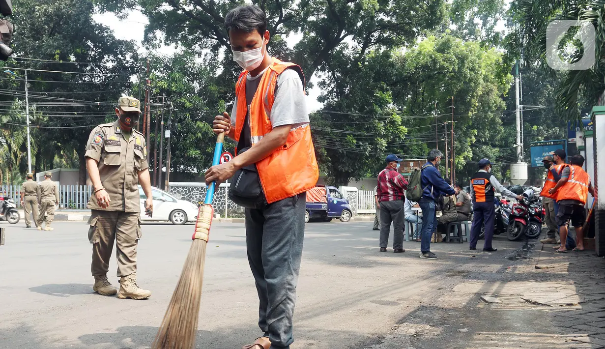 Warga menyapu jalan saat terjaring operasi tertib masker dalam rangka penerapan protokol kesehatan COVID-19 di Jalan Fatmawati, Jakarta, Kamis (10/3/2022). Pelanggar disanksi kerja sosial menyapu jalan atau denda Rp250 ribu dan menandatangani surat pernyataan tak mengulangi.(merdeka.com/Arie Basuki)