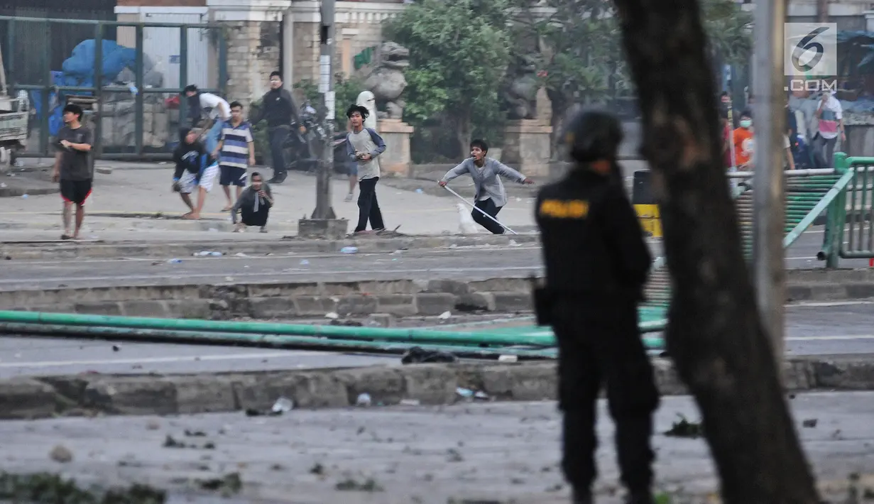 Bentrok antara polisi dan massa aksi di kawasan Tanah Abang, Jakarta, Rabu (22/5/2019).  Beberapa kelompok massa menggunakan benda-benda keras hingga mercon untuk menahan laju petugas keamanan. (Liputan6.com/Herman Zakharia)