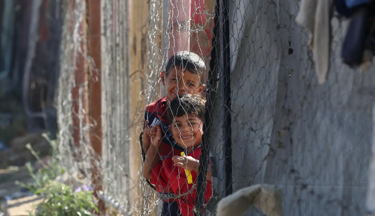 Anak-anak berdiri di samping tenda-tenda di kamp yang menampung para pengungsi Palestina di kamp Al-Bureij, Jalur Gaza tengah pada 7 Juli 2025. (Eyad BABA/AFP)