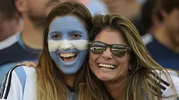 Seorang suporter menghiasi wajahnya dengan coretan warna bendera Argentina saat menyaksikan laga final piala dunia, Brasil, Senin (14/7/14). (AFP PHOTO/JUAN MABROMATA)