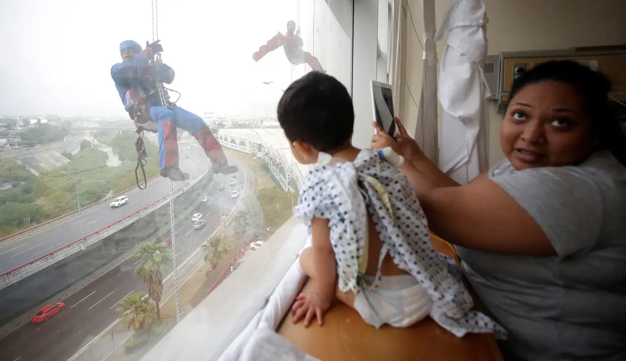Petugas pembersih kaca berkostum superhero bergelantungan di luar jendela untuk menghibur pasien anak di rumah sakit anak-anak di Guadalupe, Meksiko, 30 April 2019. Pemandangan tidak biasa ini membuat para pasien anak di rumah sakit tersebut terkesima. (REUTERS/Daniel Becerril)