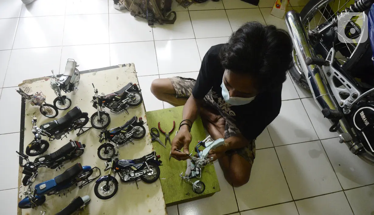 Perajin Wawang Kurniawan (38) menyelesaikan pembuatan miniatur motor RX King di Kelurahan Serua, Ciputat, Tangerang Selatan, Sabtu (17/10/2020). Miniatur dari limbah korek api, pipa plastik, kabel, kaleng minuman, dan kawat itu dijual seharga Rp 400 - Rp 450 ribu per unit. (merdeka.com/Dwi Narwoko)