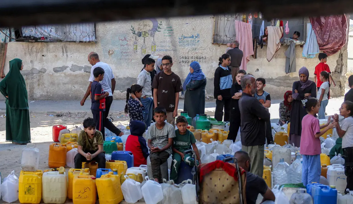 Orang-orang yang terlantar akibat perang menunggu dengan wadah air untuk mengisi persediaan mereka dari tangki air di kamp penampungan, Khan Yunis, Jalur Gaza Selatan pada 6 Juni 2026. (Bashar Taleb/AFP)