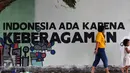 Warga melintas di depan tulisan mural di Lapangan Kebagusan, Jakarta, Rabu (15/2). Jelang menggunakan hak pilihnya pada Pilkada, Ketua Umum PDI-P Megawati Soekarnoputri menggoreskan tinta pada salah satu gambar. (Liputan6.com/Helmi Fithriansyah)
