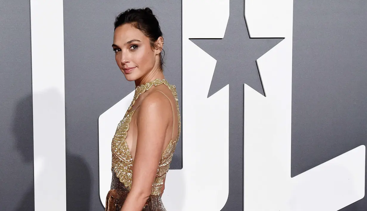 Aktris Gal Gadot berpose saat tiba menghadiri pemutaran perdana film produksi Warner Bros 'Justice League' di Teater Dolby di Hollywood, California, AS (13/11). Gal Gadot tampil cantik dengan gaun emas berkilauan. (Photo by Chris Pizzello/Invision/AP)