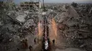 Dekorasi sederhana khas Ramadan tetap dipasang oleh warga Palestina di Gaza untuk menghadirkan suasana hangat dan solidaritas. Tampak dalam foto, warga Palestina duduk di meja panjang di tengah reruntuhan bangunan yang hancur untuk berbuka puasa bersama, selama bulan suci Ramadan di Khan Younis, Jalur Gaza, Kamis 19 Februari 2026. (AP Photo/Abdel Kareem Hana)