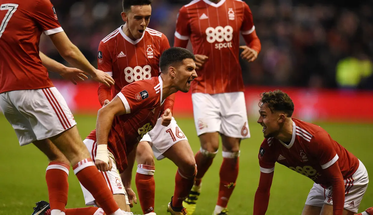 Para pemain Nottingham Forest merayakan gol yang dicetak oleh Eric Lichaj ke gawang Arsenal pada laga Piala FA di Stadion City Ground, Minggu (7/1/2018). Arsenal takluk 2-4 dari Nottingham Forest. (AFP/Oli Scarff)