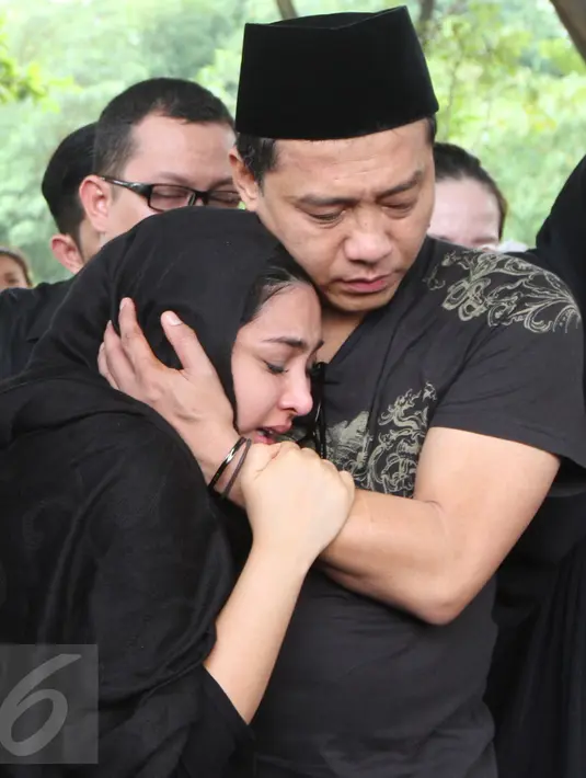 Anang Hermasnyah mencoba menenangkan istrinya yang juga penyanyi, Ashanty selama pemakaman sang ibunda, Ratu Farida, di TPU Jeruk Purut, Jakarta, Senin (7/11). Tangis Ashanty tak terbendung melihat pemakaman sang ibu. (Liputan6.com/Herman Zakharia)