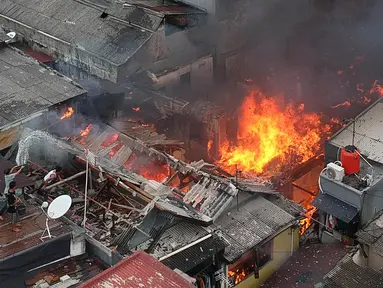 Warga berusaha memadamkan api dengan menyiramkan air saat terjadi kebakaran di kawasan Tanah Tinggi, Johar Baru, Jakarta, Selasa (26/6). Sebanyak 18 unit mobil pemadam kebakaran telah diterjunkan ke lokasi. (Liputan6.com/Arya Manggala)