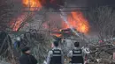 Otoritas setempat mengatakan, belum ada laporan korban jiwa dalam insiden tersebut, namun 47 warga dievakuasi. Tampak dalam foto, petugas pemadam kebakaran berjuang memadamkan api di permukiman kumuh Desa Guryong, pemukiman informal terbesar di Seoul, Korea Selatan, pada Jumat 16 Januari 2026. (YONHAP/AFP)