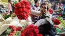 Aktivitas pedangang bunga mawar di pasar bunga grosir di Kolkata, India (7/2). Jelang perayaan hari Valentine, bunga mawar banyak diburu dari tanggal 7 Februari dengan ditandai dengan Rose Day. (AFP Photo/Dibyangshu Sarkar)