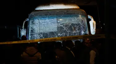 Pasukan keamanan berdiri di dekat sebuah bus wisata setelah serangan bom pinggir jalan di sebuah daerah dekat Piramida Giza di Kairo, Mesir (28/12). Insiden tersebut menewaskan  dua turis Vietnam dan 12 lainnya terluka. (AP Photo/Nariman El-Mofty)