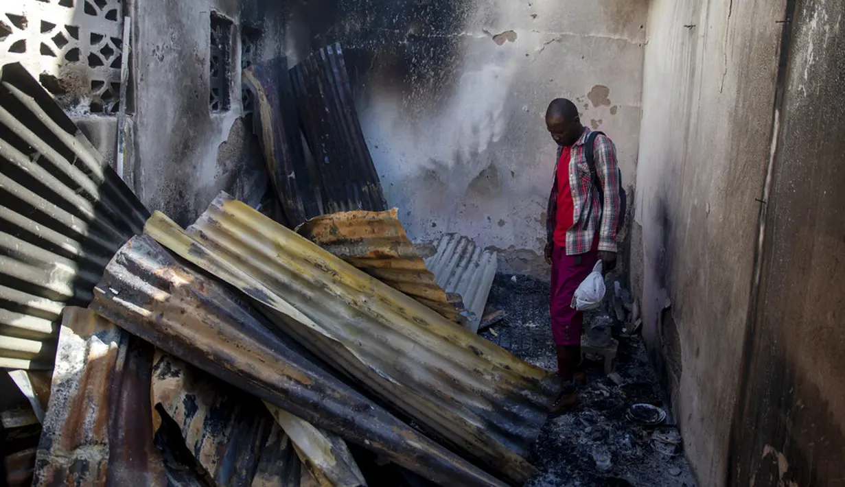 Seorang warga melihat atap seng yang runtuh dalam sebuah rumah yang rusak usai ledakan truk pengangkut BBM di Cap-Haitien, Haiti, 14 Desember 2021. Sekitar 40 rumah di daerah itu ikut rusak, tetapi belum ada rincian jumlah korban di dalam rumah. (AP Photo/Joseph Odelyn)