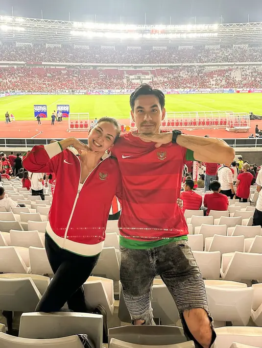 Sebagai pasangan yang dikenal kerap tampil serasi, Donna Agnesia memilih jaket Timnas merah, sementara sang suami, Darius Sinathrya, mengenakan jersey Timnas dengan aksen list hijau. Pilihan outfit mereka menunjukkan kombinasi sporty yang tetap modis. [@dagnesia].