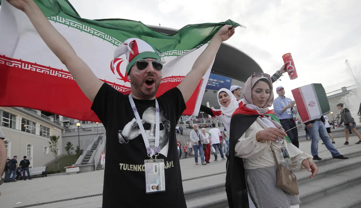 Seorang fans mengibarkan bendera Iran saat merayakan kemenangan atas Maroko pada laga Piala Dunia di Saint Petersburg, Rusia, Jumat, (15/6/2018). Iran Menang 1-0 atas Maroko. (AP/Dmitri Lovetsky)